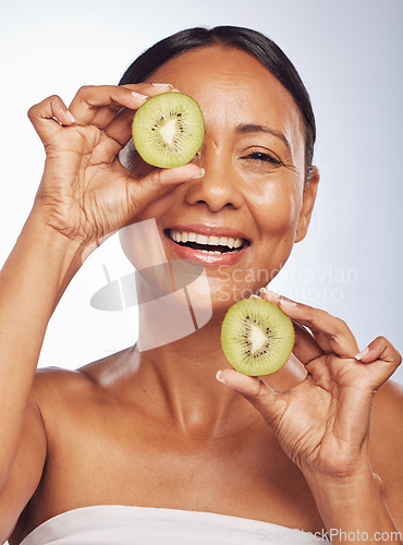 Image of Face, skincare and senior woman with kiwi in studio isolated on a white background. Food, natural fruit and portrait of happy model with nutrition for wellness, healthy diet and anti aging for beauty