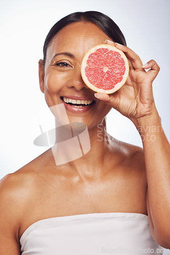 Image of Skincare, face and mature woman with grapefruit in studio isolated on a white background. Portrait, natural fruit and happy model with food for nutrition, wellness and healthy diet for anti aging.