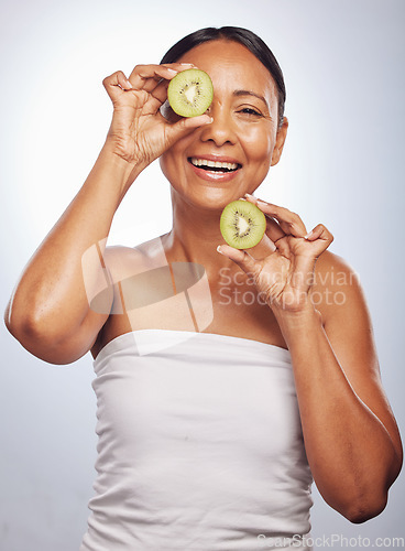 Image of Skincare, portrait and senior woman with kiwi in studio isolated on a white background. Food, natural fruit and face of happy model with nutrition for wellness, healthy diet and anti aging for beauty