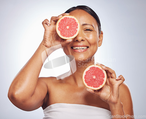 Image of Face, happy and senior woman with grapefruit in studio isolated on a white background. Skincare, natural fruit and portrait of model with food for nutrition, healthy diet and vitamin c for anti aging