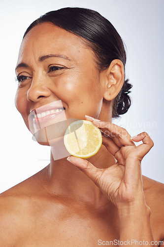 Image of Thinking, orange and senior woman with skincare, dermatology and treatment against a white studio background. Mature female person, happy lady or model with citrus fruit, natural beauty and vitamin c