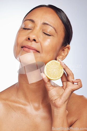 Image of Cosmetics, orange and senior woman with skincare, dermatology and vitamin c against a white studio background. Mature female person, self care and model with citrus fruit, natural beauty and health