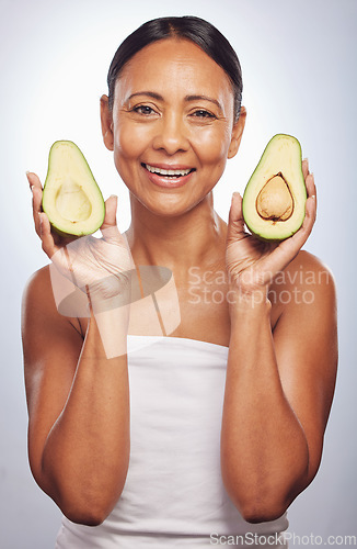 Image of Portrait, skincare and senior woman with avocado in studio isolated on a white background. Face, natural fruit and happy model with food for vegan nutrition, healthy diet and omega 3 for anti aging.