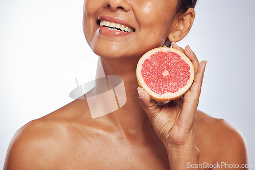 Image of Skincare, beauty and happy woman with grapefruit in studio isolated on a white background. Food, natural fruit and hand of model with nutrition for wellness, healthy diet and vitamin c for anti aging