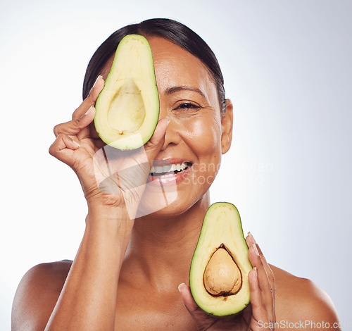 Image of Senior, anti aging and portrait of woman with avocado for skincare, nutrition or diet. Happy, face and elderly model or lady with food for wellness, beauty and detox isolated on a studio background