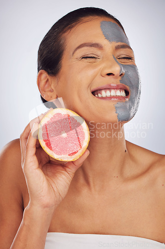 Image of Woman, skincare, with grapefruit and face mask with charcoal, clay or natural beauty product for wellness, detox or nutrition. Fruit, healthy cosmetics and girl happy with vitamin c or facial care