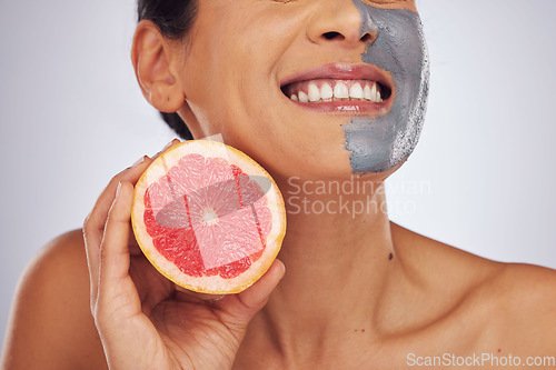 Image of Skincare, grapefruit and woman with a face mask with charcoal, clay or natural beauty product for wellness, detox or nutrition. Fruit, healthy cosmetics and girl happy with vitman c or facial care