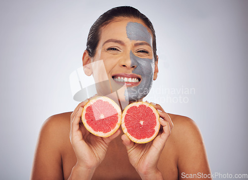 Image of Woman with grapefruit, skincare and face mask with charcoal, clay or natural beauty product with vitamin c, wellness or detox. Fruit, healthy cosmetics and girl happy with dermatology or facial care