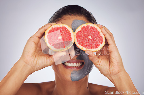 Image of Hands with grapefruit, skincare and face mask with clay, charcoal or natural beauty product for wellness, detox or nutrition. Fruit, woman in funny pose and healthy cosmetics for facial care
