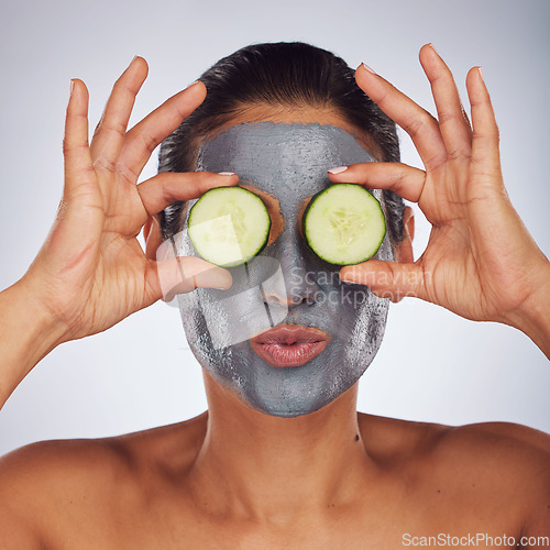 Image of Eyes, cucumber and mask with a model woman in studio on a gray background for an antiaging facial treatment. Face, skincare and food with a young female person using cosmetic clay on her face