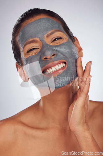 Image of Happy woman, charcoal mask and portrait for beauty, aesthetic dermatology and self care on studio background. Mature female model touch face with clay skincare product, facial cosmetics and smile