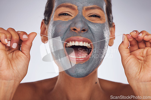 Image of Portrait, face mask and a woman flossing teeth for skincare, dental hygiene and wellness. Happy, cleaning and a model or girl with gear for tooth cleaning and a facial isolated on a studio background