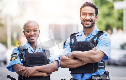 Image of Happy, portrait and police with arms crossed in the city for security, safety and justice on the street. Team, pride and a black woman and a man with confidence working in urban crime together