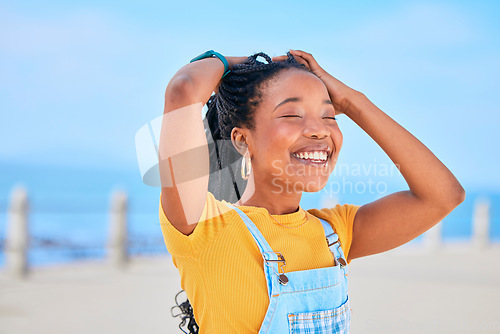 Image of Face, smile and hair with a black woman on a blurred background by the ocean during summer vacation. Eyes closed, happy and braids with a young female person outdoor on the promenade for a holiday