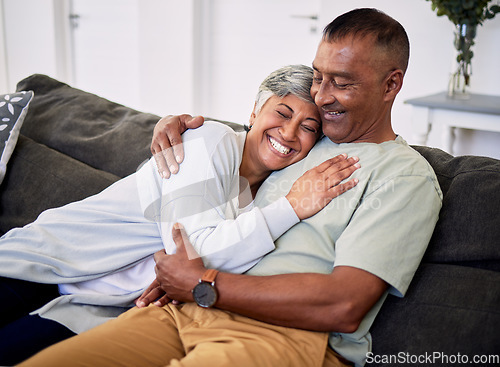 Image of Hug, marriage and senior woman or man on sofa with love or care in home to relax. Retirement, smile and elder couple with embrace in living room for bonding together or quality time in house.