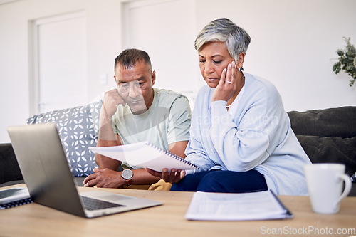 Image of Senior couple, tax documents and stress with laptop in living room for planning, thinking and budget. Elderly man, woman and paperwork for financial compliance, anxiety or debt in retirement on sofa