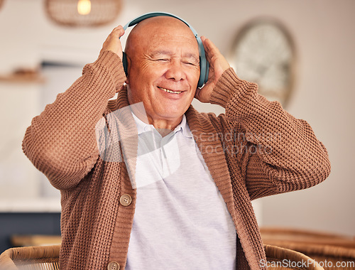 Image of Happy, senior and a man with headphones for music, podcast or audio while in a home. Smile, relax and an elderly person with radio, streaming track or listening to a playlist on electronic gear