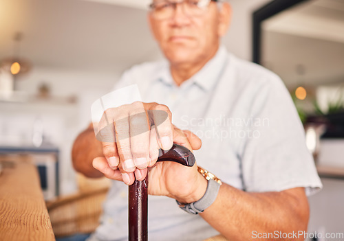 Image of Hands, serious and portrait of a man with a cane for medical help, senior support and health. Sad, house and an elderly person with a disability in the living room with a walking stick closeup