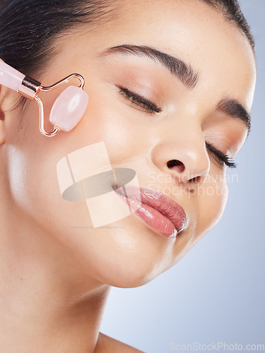 Image of Happy woman, beauty or rose quartz roller for face massage, healthy skincare on studio background. Glow, grooming treatment or model smiling with dermatology facial cosmetics or product to relax