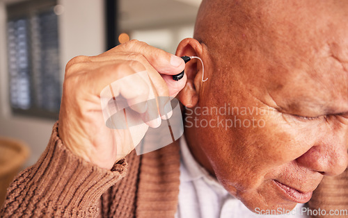 Image of Hearing aid, ear and a senior man with a disability in his home closeup for listening to noise or volume. Healthcare, medical or deaf with a mature male person in his retirement house for wellness