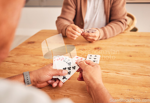 Image of Hands, cards and a senior man playing a game at a table in the living room of a retirement home. Thinking, planning and fun with an elderly male pensioner in a house closeup for entertainment