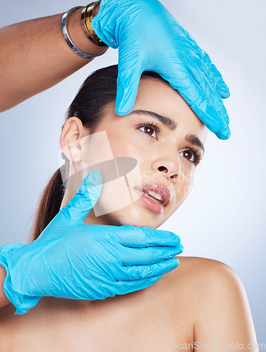 Image of Woman, plastic surgery and hands on face in studio, check and cosmetics for beauty vision by background. Young girl, model and surgeon gloves with thinking, inspection and measurement for aesthetic