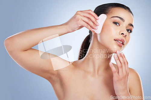 Image of Skincare, gua sha and asian woman portrait in studio for anti aging, cosmetic or facial massage on grey background. Rose quartz, face and lady wellness model with luxury, beauty or lymphatic drainage