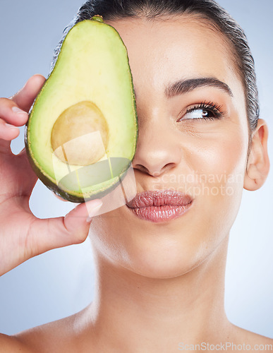 Image of Avocado, skincare and face of woman in studio with doubt of natural detox, wellness or omega 3 treatment on white background. Fruit, diet or lady model unsure of anti aging or vitamin c facial beauty