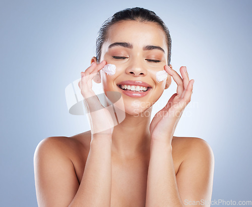 Image of Skincare, hand and happy woman with face cream in studio for anti aging, wellness or hydration on grey background. Facial, smile and latino model with sunscreen, lotion or beauty mask application