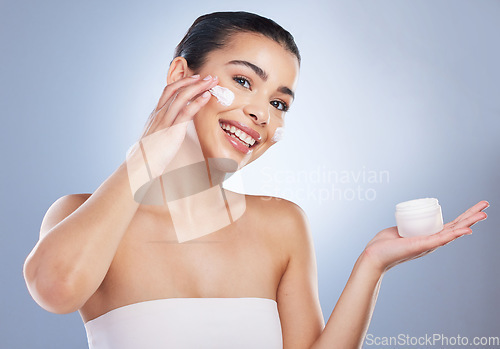 Image of Skincare, face cream and portrait of woman in studio for natural, health or wellness face routine. Beauty, self care and female model with facial spf, lotion or sunscreen isolated by gray background.