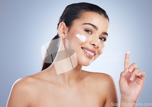Image of Portrait, skincare and happy woman with face cream in studio for anti aging, wellness or hydration on grey background. Facial, smile and lady model with sunscreen, lotion or beauty mask application