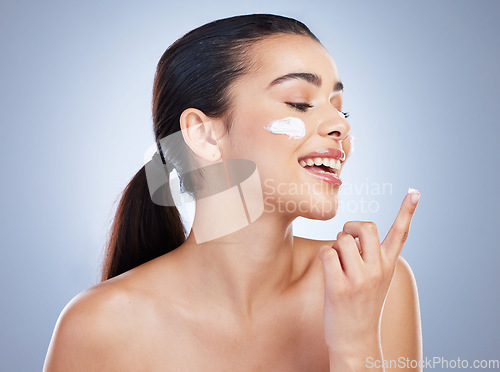 Image of Skincare, hand and happy woman with face cream in studio or anti aging, collagen or hydration on grey background. Finger, smile and lady model with facial sunscreen, lotion or beauty mask application