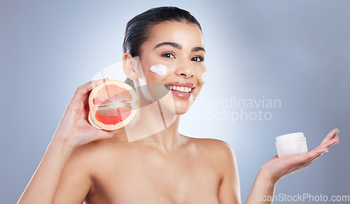 Image of Skincare, face cream and woman with grapefruit in studio for a natural, organic or health facial routine. Beauty, self care and female model with citrus fruit and spf for treatment by gray background