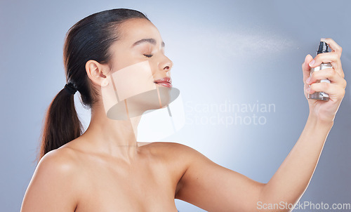 Image of Beauty, spray and face with woman for skincare in blue or isolated background for natural routine. Girl, wellness and facial cosmetic for self care with bottle or dermatology in mock up or studio.