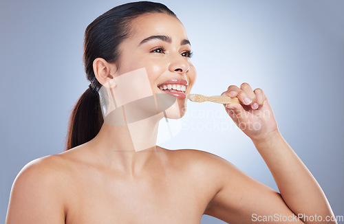 Image of Woman, wood toothbrush and studio for cleaning mouth, healthy smile or eco friendly cosmetics by background. Girl, model and sustainability for dental self care, teeth whitening and happy with vision