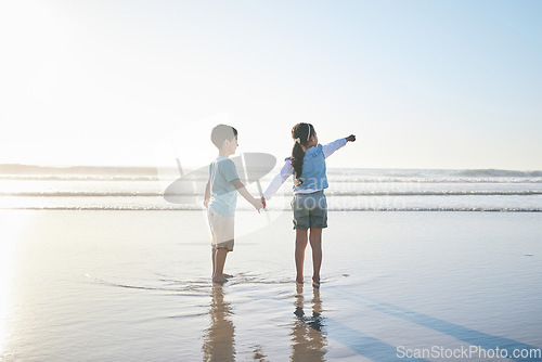 Image of Beach, travel and back of children holding hands while on a vacation, holiday or adventure. Freedom, love and kid siblings playing and bonding together by the ocean on a tropical summer weekend trip.