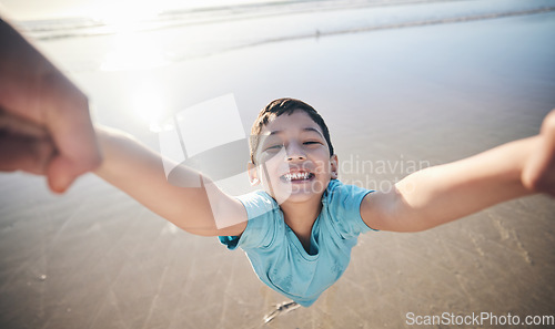 Image of Person, spin kid and pov at beach, portrait and smile for game, excited and playing by water in sunshine. Parent, young boy child and swing with speed, love and bonding with holding hands by ocean