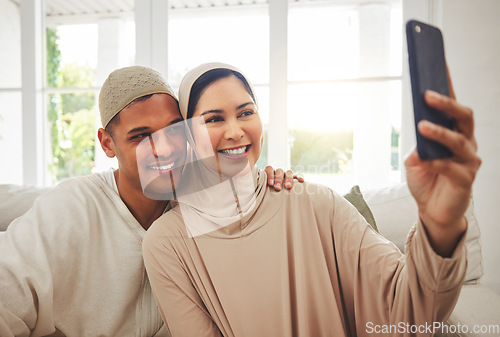 Image of Selfie, Islam and happy couple on couch with smile, culture and love in living room in Indonesia. Marriage, man and woman in hijab on sofa together with respect, religion and photo for social media.