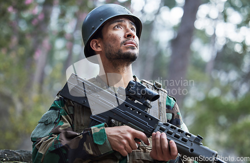 Image of Soldier, army and man thinking with gun in forest training, outdoor shooting or military exercise, mission and focus. Rifle, veteran and young person search woods or nature in battlefield gear vision