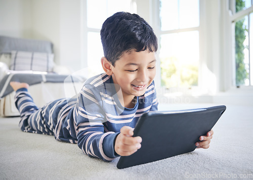 Image of Young boy, tablet and games or cartoon streaming online with internet, e learning and relax on carpet in house. Watch animation film, male kid at home and connection, entertainment and subscription