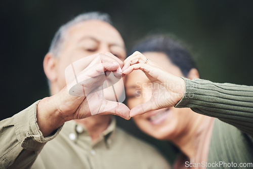 Image of Heart, hands and a senior couple in a house for love, care and showing an emoji together. Happy, trust and an elderly man and woman with a gesture for romance, marriage or valentines day with bokeh