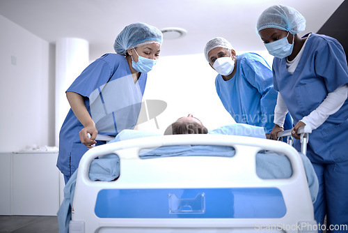 Image of Covid, surgery and doctors with a patient for a check, healthcare support and consultation. Hospital, medical and surgeons or nurses helping a sick patient in a bed with face mask for nursing