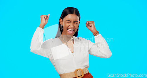 Image of Yes, cheers and winner woman isolated on blue background celebration, excited and fist pump for bonus, lotto or prize. Wow, winning and indian person celebrate success, competition or news in studio