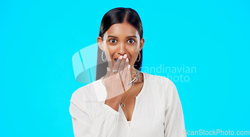 Image of Woman, surprise and face with hand on mouth for comic story, secret or laugh for funny gossip by blue background. Young, gen z model and indian girl with laughing, amazed and wow for news in portrait