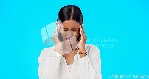 Image of Woman, headache and studio with hands, migraine and stress on head to massage temple by blue background. Young indian model, pain and anxiety with mental health, fatigue and burnout by backdrop