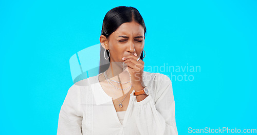 Image of Woman, coughing and sore throat in studio by blue background with medical, health or wellness problem. Young gen z girl, indian model and sick with hand on mouth for cough, healthcare or allergies
