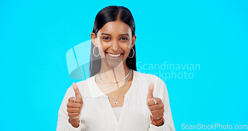 Image of Thumbs up, excited and success by woman with hand gesture for approval isolated in studio blue background. Emoji, face and portrait of Indian female with fashion, perfection and support review