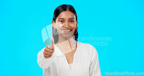 Image of Thumbs up, perfect and portrait of woman with hand gesture for success, approval and isolated in studio blue background. Emoji, face and Indian female with fashion, perfection and support review