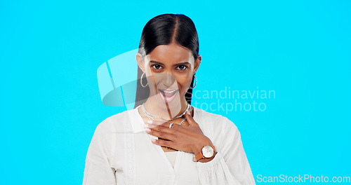 Image of Shocked, surprised and woman portrait of wow face in studio on a blue background for announcement or news. Indian female model with hand on chest for attitude, compliment or emoji for gossip or rumou