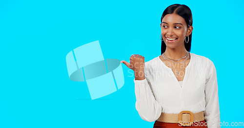 Image of Business woman, pointing and face of a Indian female in a studio gesture to mockup for advertisement. Idea, happiness and smile of a corporate employee point thumb to show mock up advertising